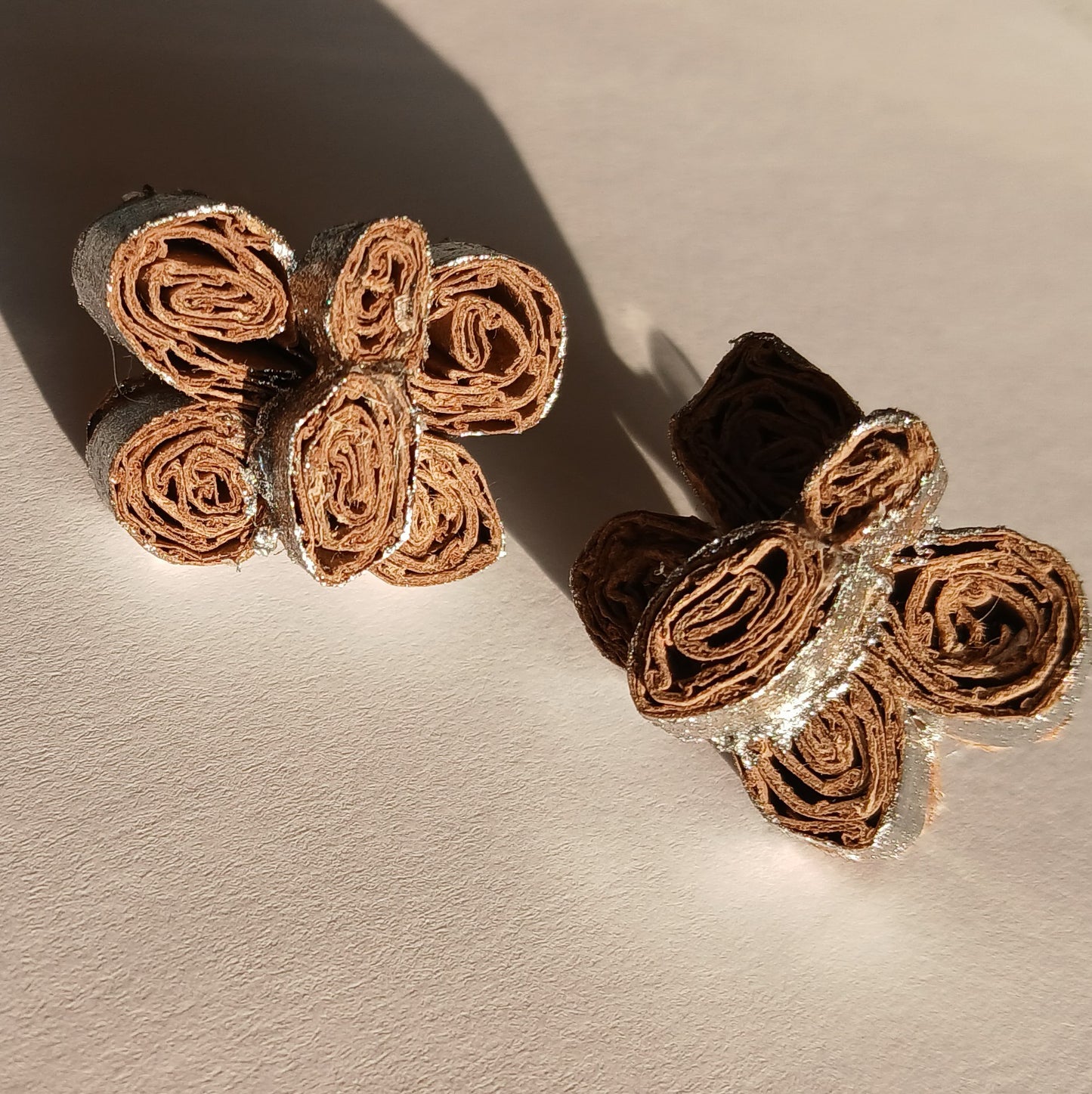 Pair of butterfly earrings on a beige background