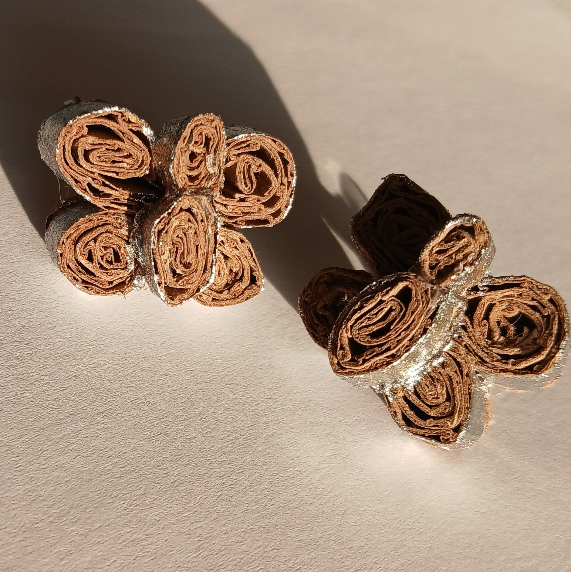 Pair of butterfly earrings on a beige background